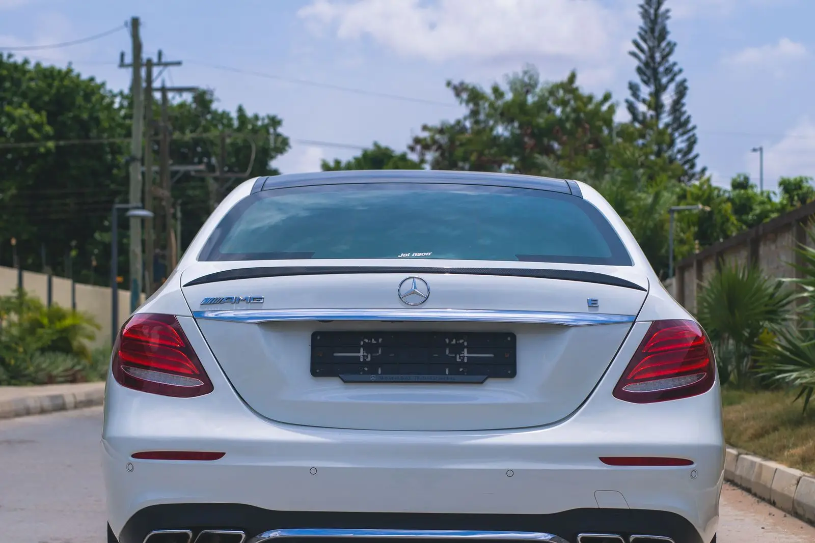 White sedan, rear view with dual exhaust