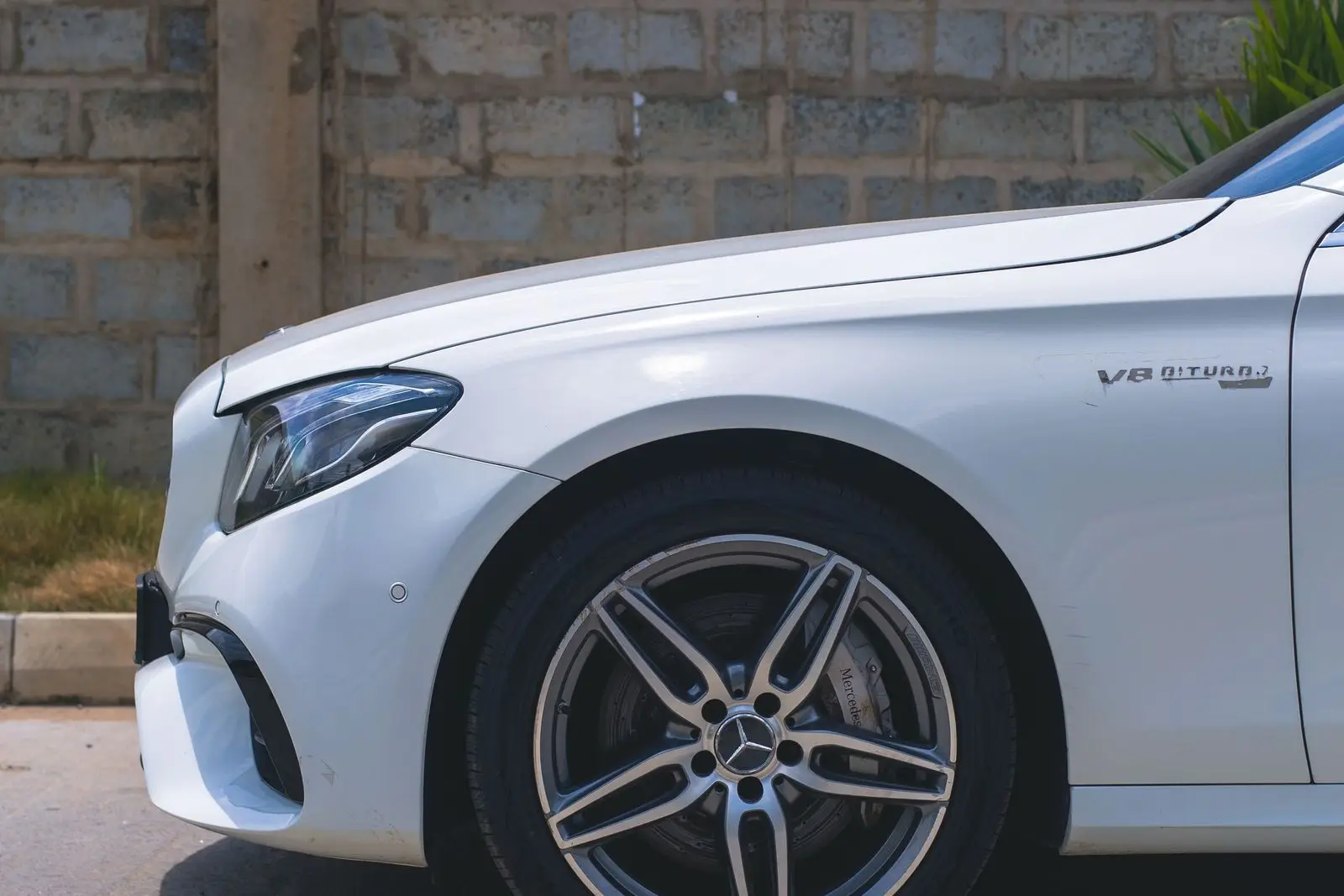 White sedan, front fender and wheel detail